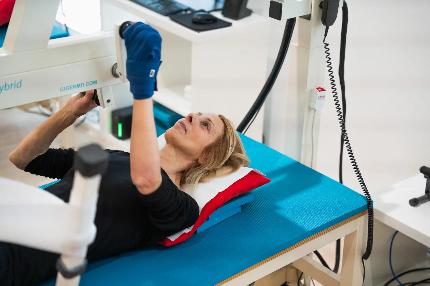 Patientin trainiert liegend mit Handfixierung am GIGER MD Hybrid – Bewegung in simulierter Schwerelosigkeit