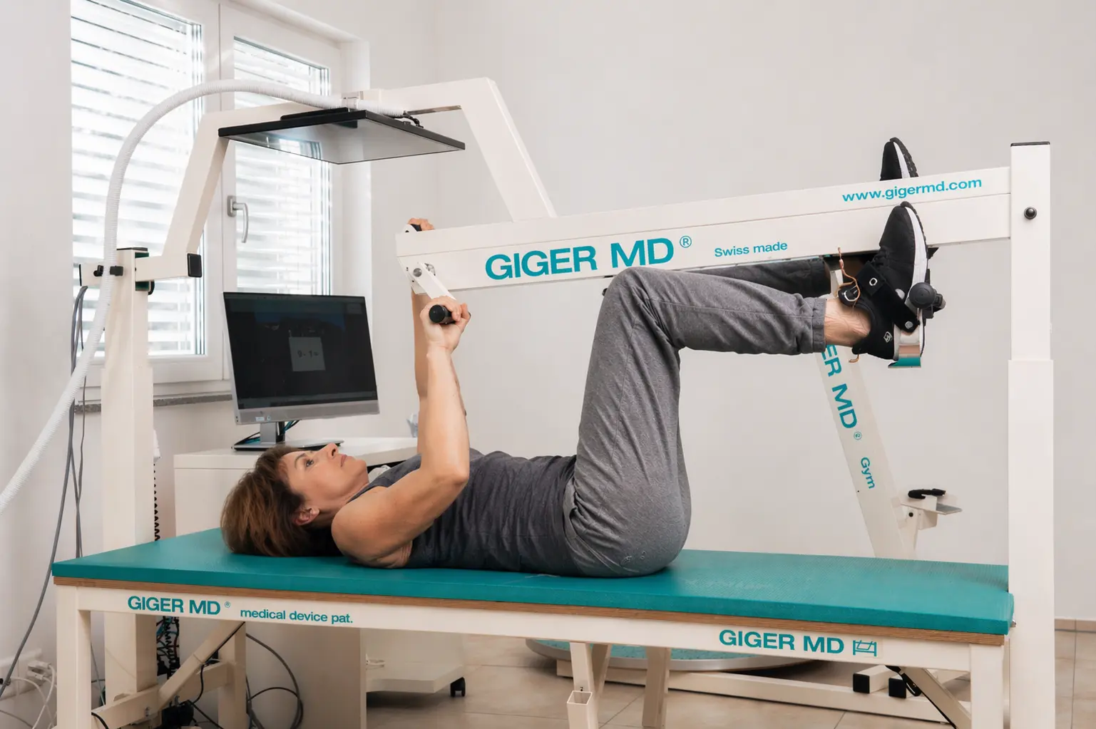 Frau trainiert bei Querschnittlähmung Arme und Beine auf dem GIGER MD Therapiegerät